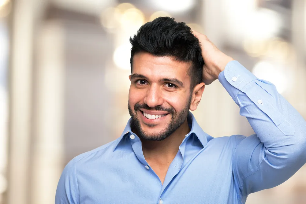 Paciente feliz com seu nevo cabelo natural após se recuperar do transplante capilar